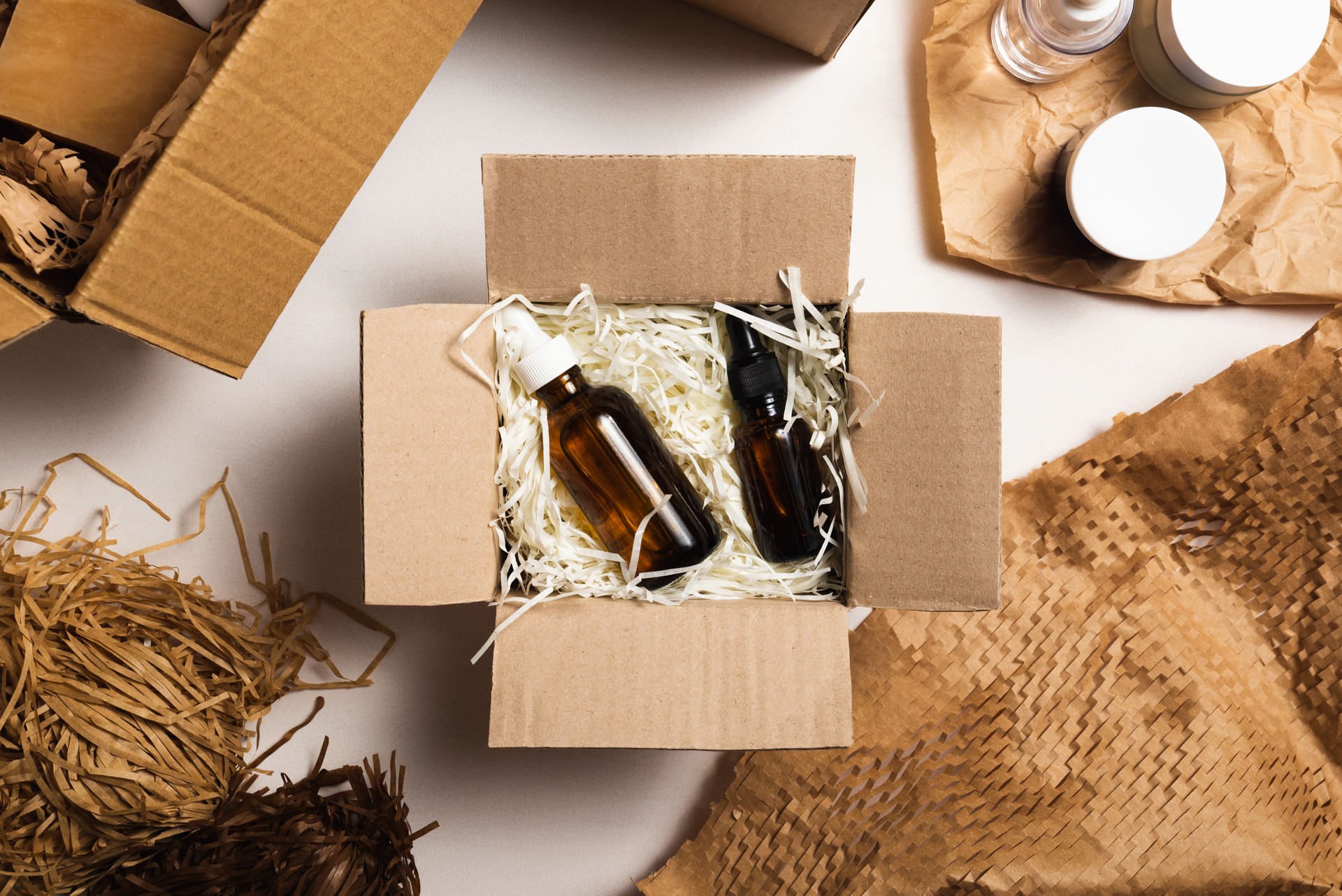Beauty box with serum bottles on shredded white paper